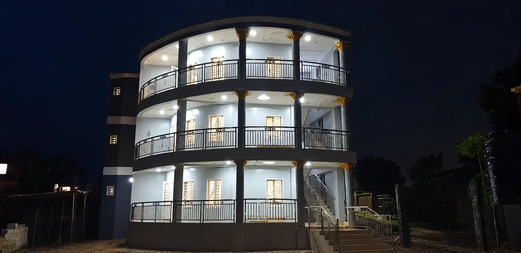 Façade de nuit de l’immeuble à Ansoumaniah avec balcons et escalier extérieur