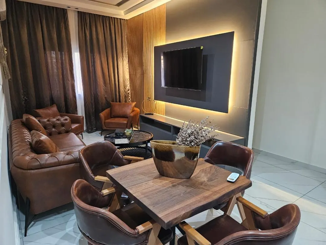 Séjour et salle à manger avec canapé, fauteuils et télévision