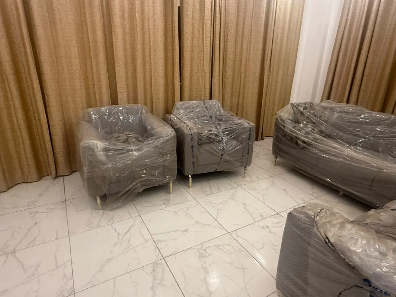 Séjour avec fauteuils et canapés sous housses de protection